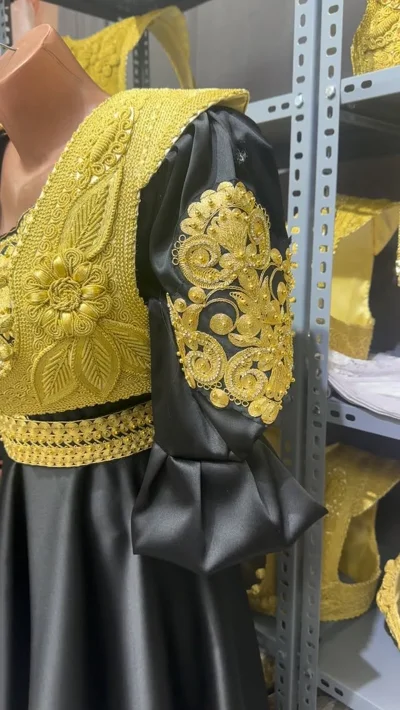 Veshje tradicionale e zezë me jelek ari
