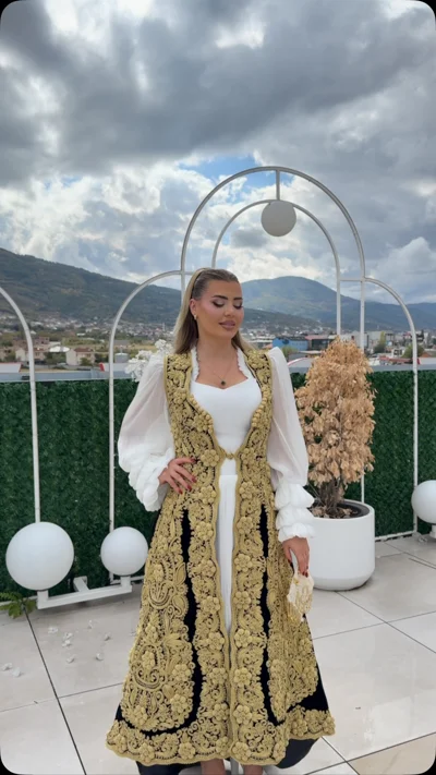 Xhurdi e zezë me ari mbi fustan të bardhë