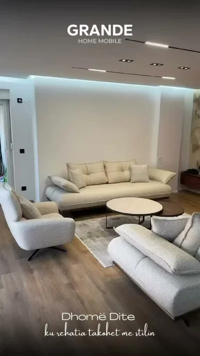 Dhomë dite me ulëse bezhë dhe tavolinë mesi