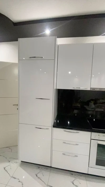 Kuzhinë e bardhë me shkëlqim dhe pllakë të zezë