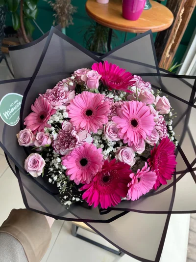 Buqetë me gerbera rozë në letër të zezë