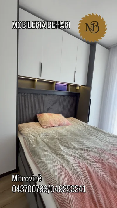 Dhomë gjumi gri me dollap mbi shtrat