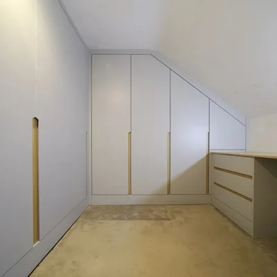 Gardërobë në mur nën pjerrësi me sirtarë
