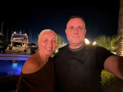 Foto e dy personave në mbrëmje pranë detit
